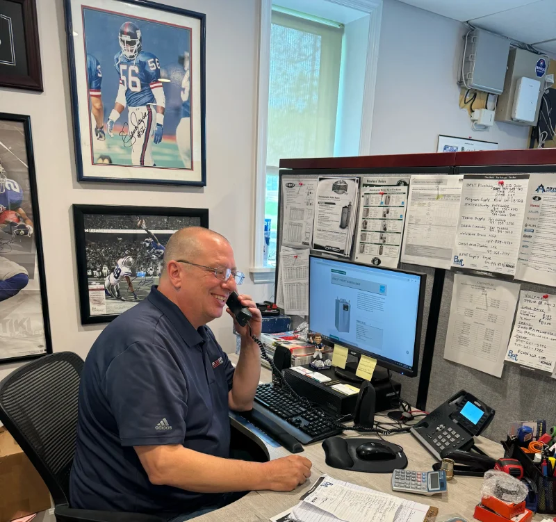 Man talking on the phone while sitting at a desk.
